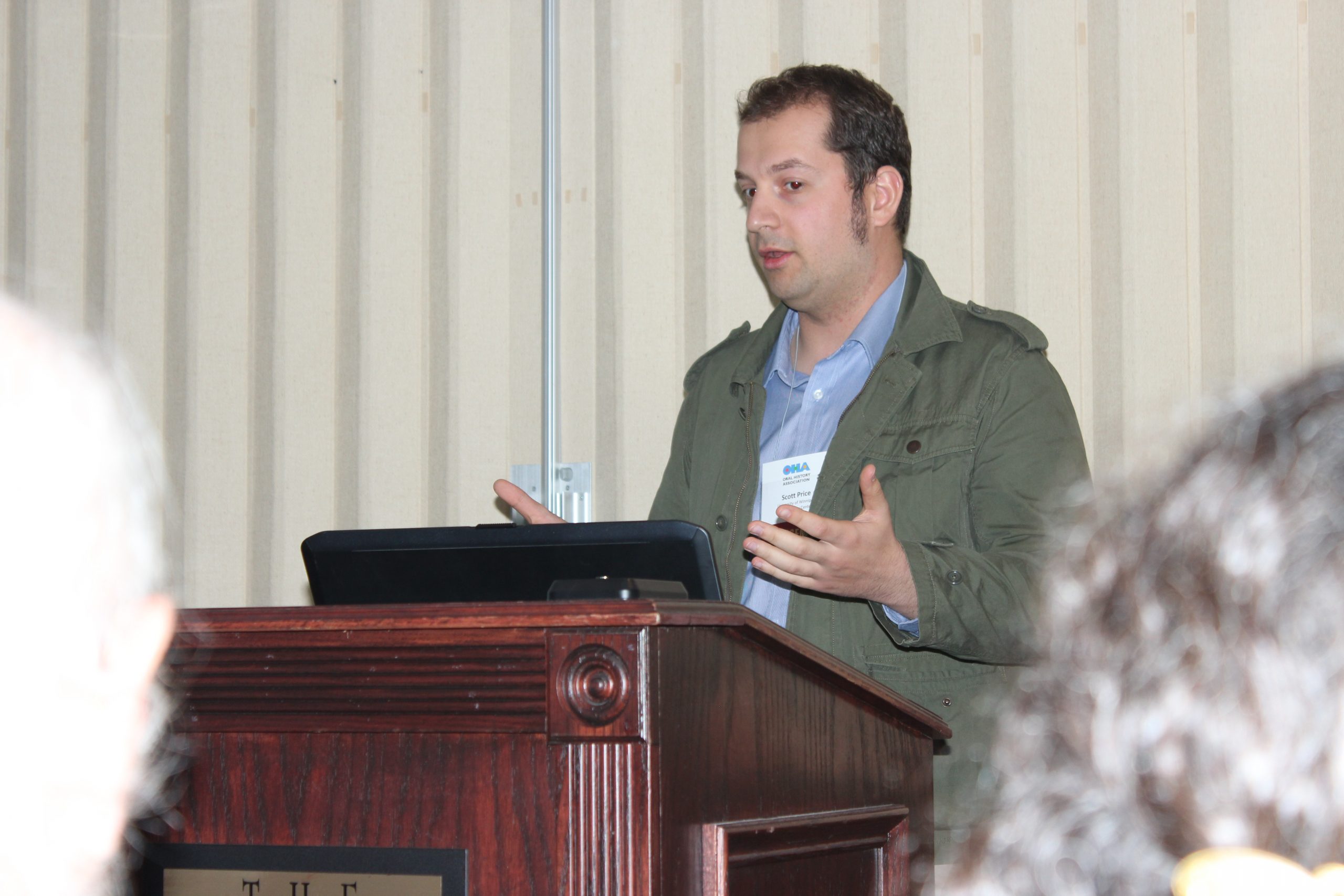 OHC Researcher Scott Price presenting at a podium.