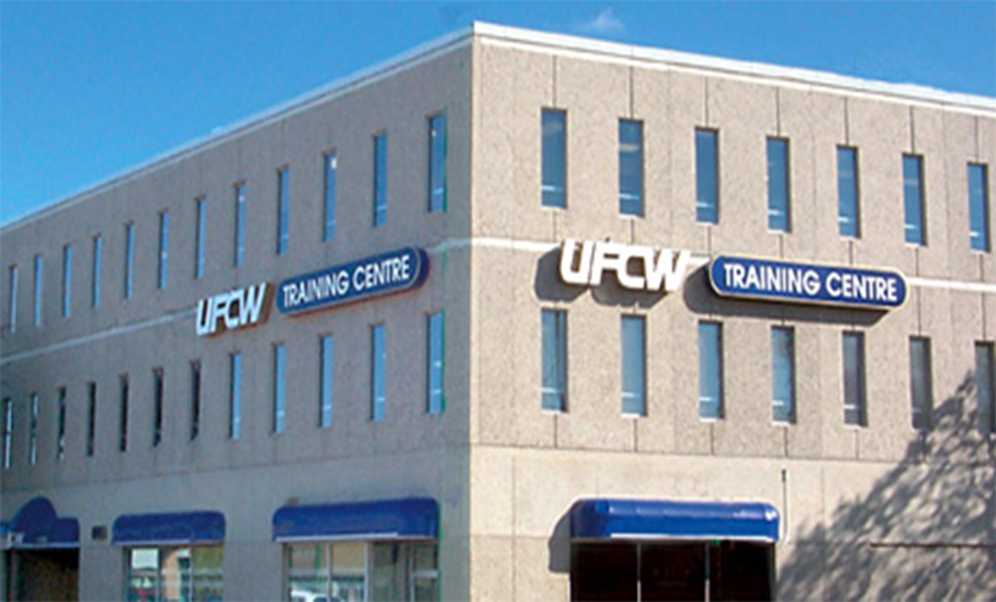 Exterior of three story building. White and blue sign: UFCW Training Centre. 
