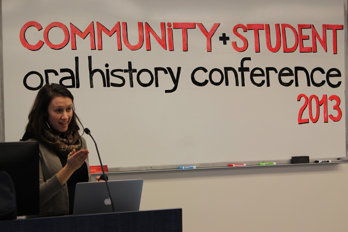Photo of Brielle Beaudin speaking at podium, whiteboard background with text: Community + Student oral history conference 2013