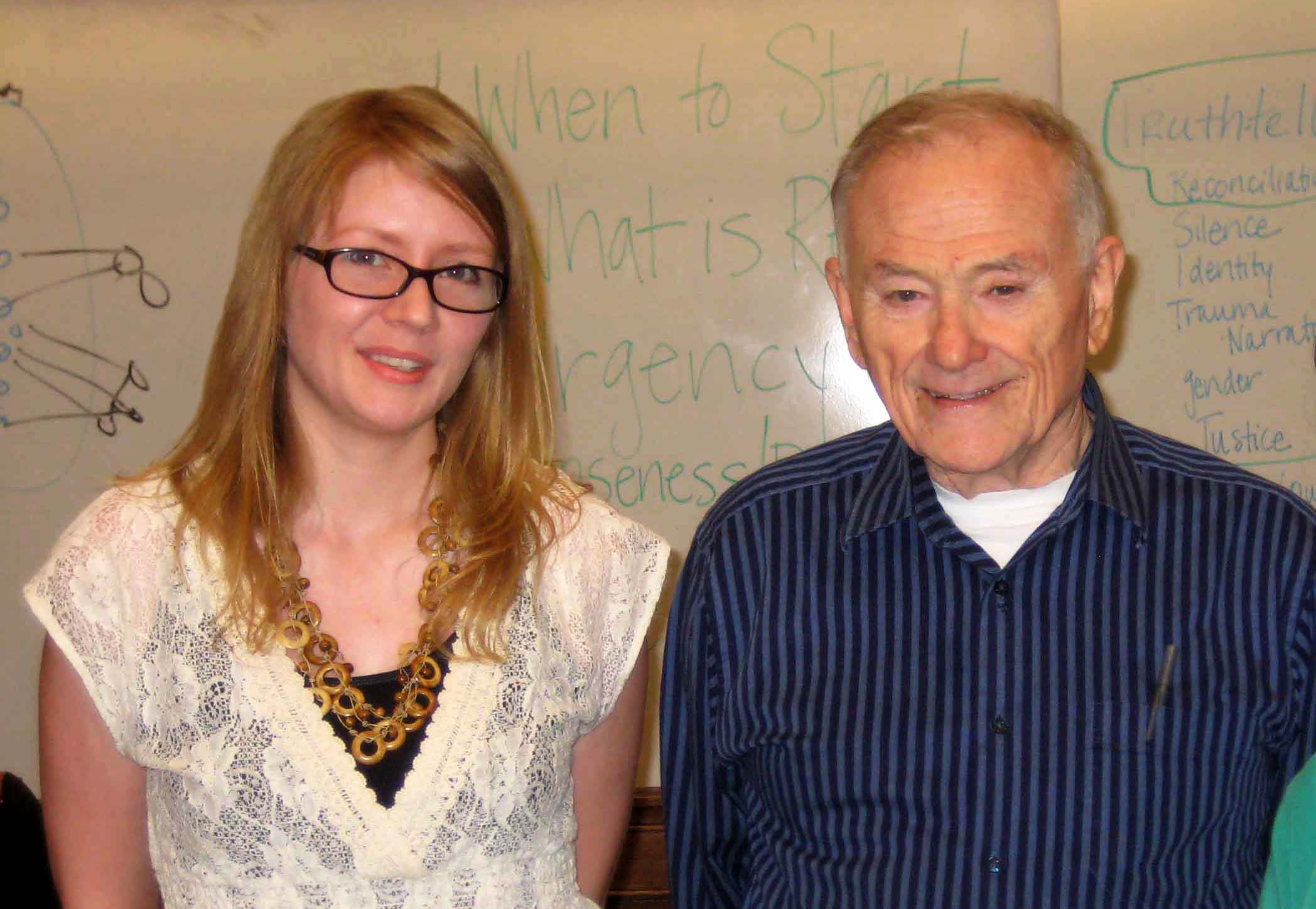Photo of Allison Penner and Ron Grele, whiteboard with lettering in background.