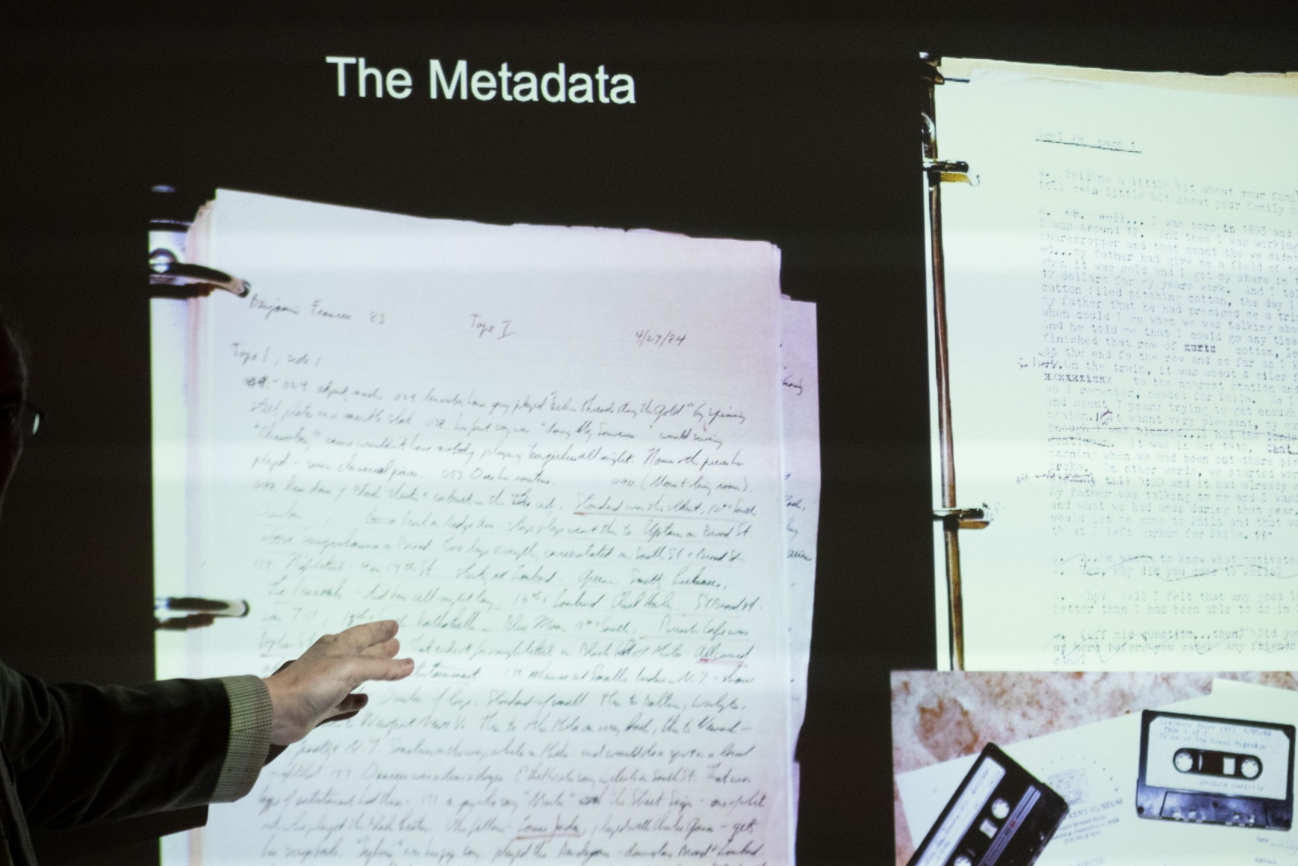 Projected slide of handwritten transcript, typewritten transcript and cassette tapes. Above title: The Metadata.