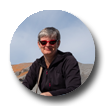 Photo of Janis Thiessen with background of rocks and blue sky.