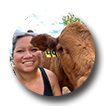 Circle photo of a woman with a brown cow.